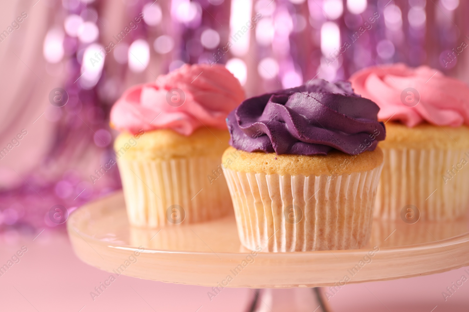 Photo of Delicious cupcakes with bright cream on pink background, closeup