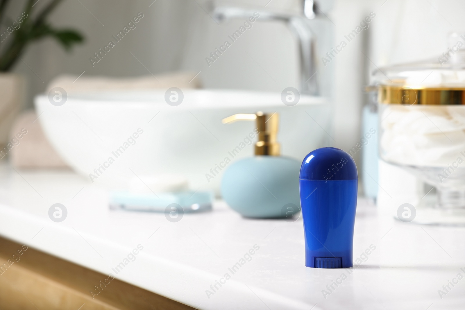 Photo of Stick deodorant and different toiletry on countertop in bathroom, space for text