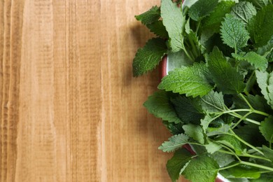 Photo of Fresh lemon balm on wooden table, top view. Space for text