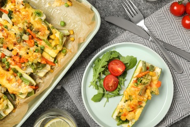 Photo of Flat lay composition with baked stuffed zucchinis served on grey table