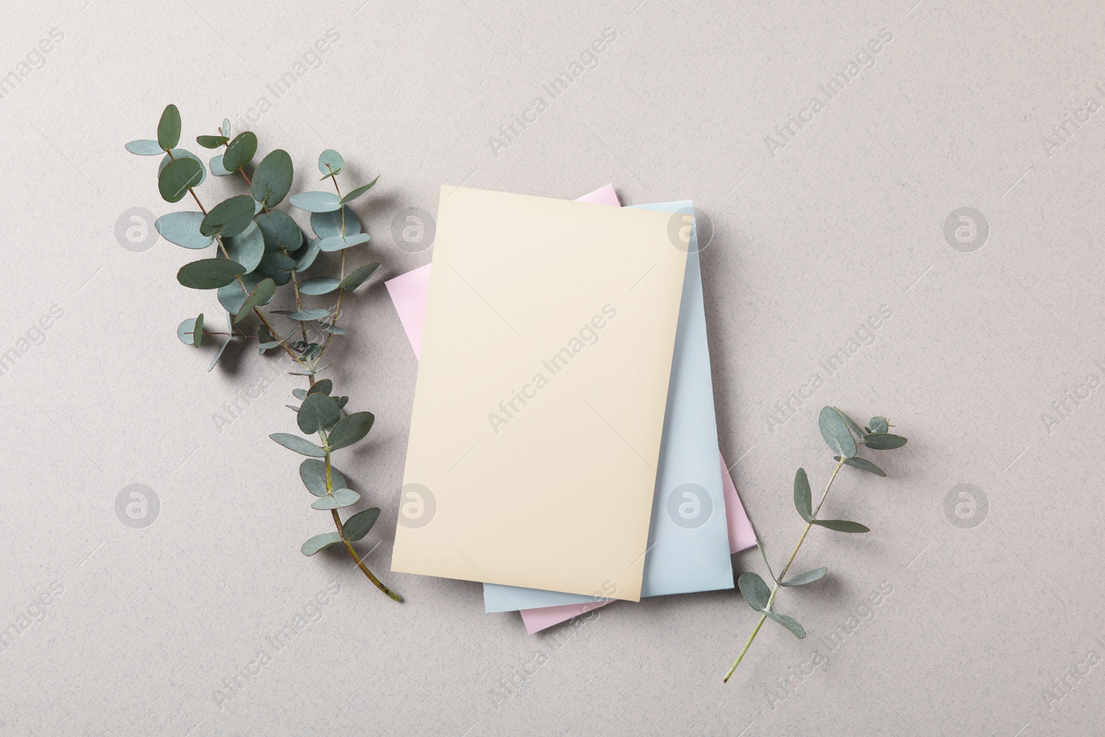 Photo of Scented sachets and eucalyptus branches on grey table, flat lay