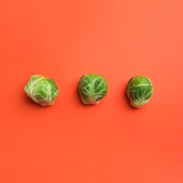 Fresh Brussels sprouts on coral background, flat lay