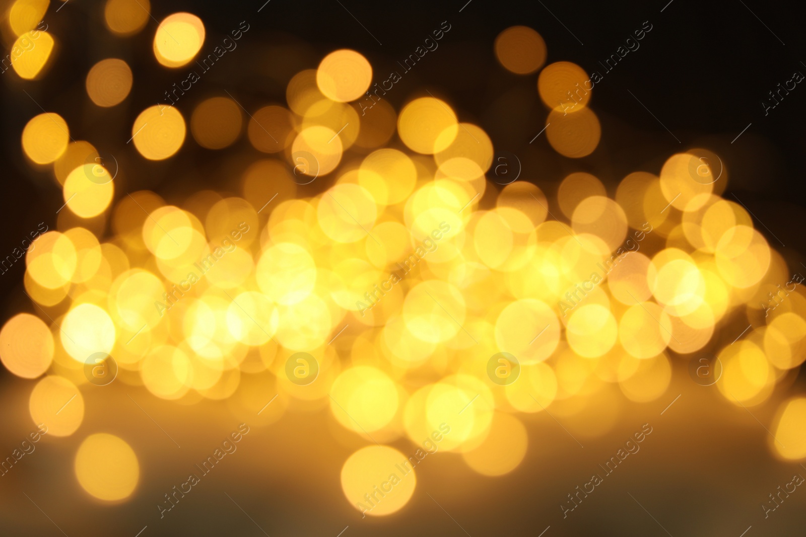 Photo of Gold glitter with bokeh effect on dark background