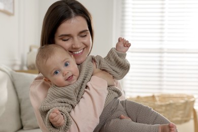 Photo of Happy young mother with her baby at home