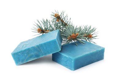 Photo of Handmade soap bars and fir branch on white background