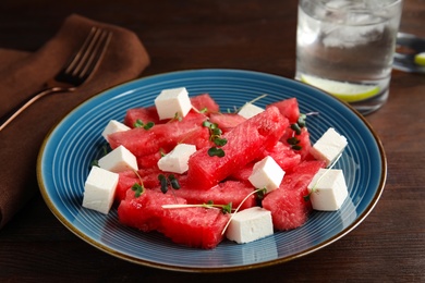 Photo of Delicious salad with watermelon and feta cheese on wooden table, closeup