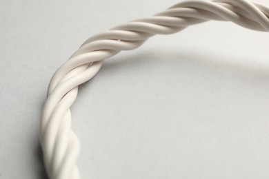 Photo of Many twisted electrical cables on light background, closeup