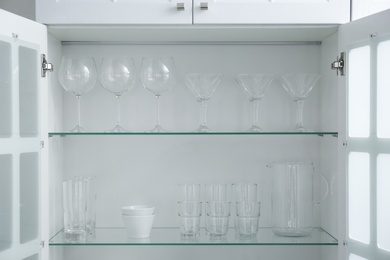 Photo of Cabinet with crockery and glassware. Order in kitchen
