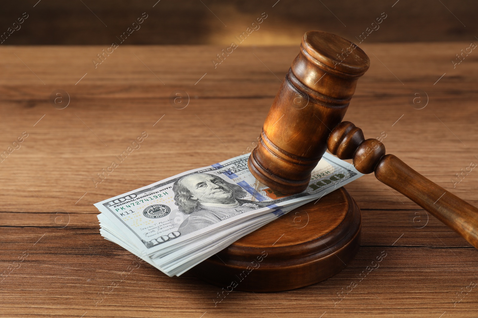 Photo of Judge's gavel and money on wooden table