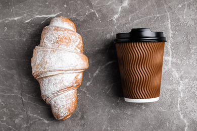 Photo of Tasty croissant and drink on brown marble table, flat lay