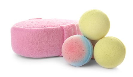 Photo of Pink sponge and bath bombs on white background