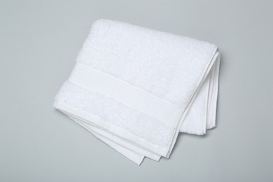 Photo of White terry towel on light grey background, top view