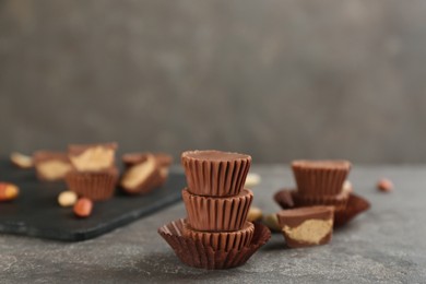 Delicious peanut butter cups on grey table