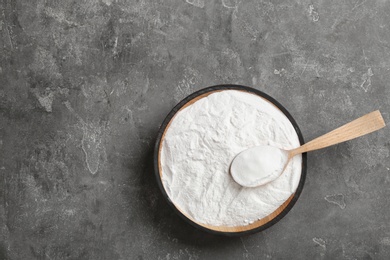 Photo of Bowl of baking soda with spoon and space for text on table, top view