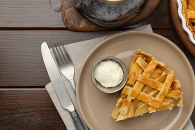 Photo of Piece of tasty homemade quince pie served on wooden table, flat lay. Space for text