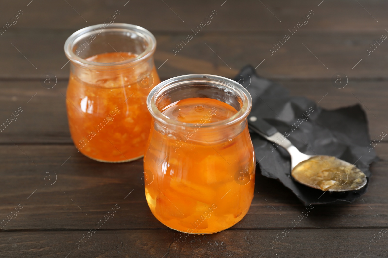 Photo of Jars with tasty sweet jam on wooden table