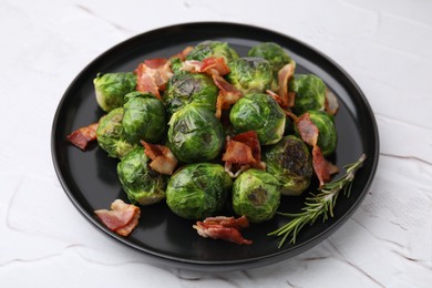 Photo of Delicious roasted Brussels sprouts, bacon and rosemary on white textured table, closeup