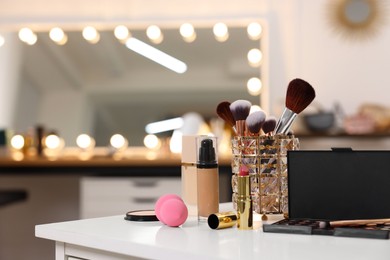 Photo of Different cosmetic products on white table in makeup room, space for text