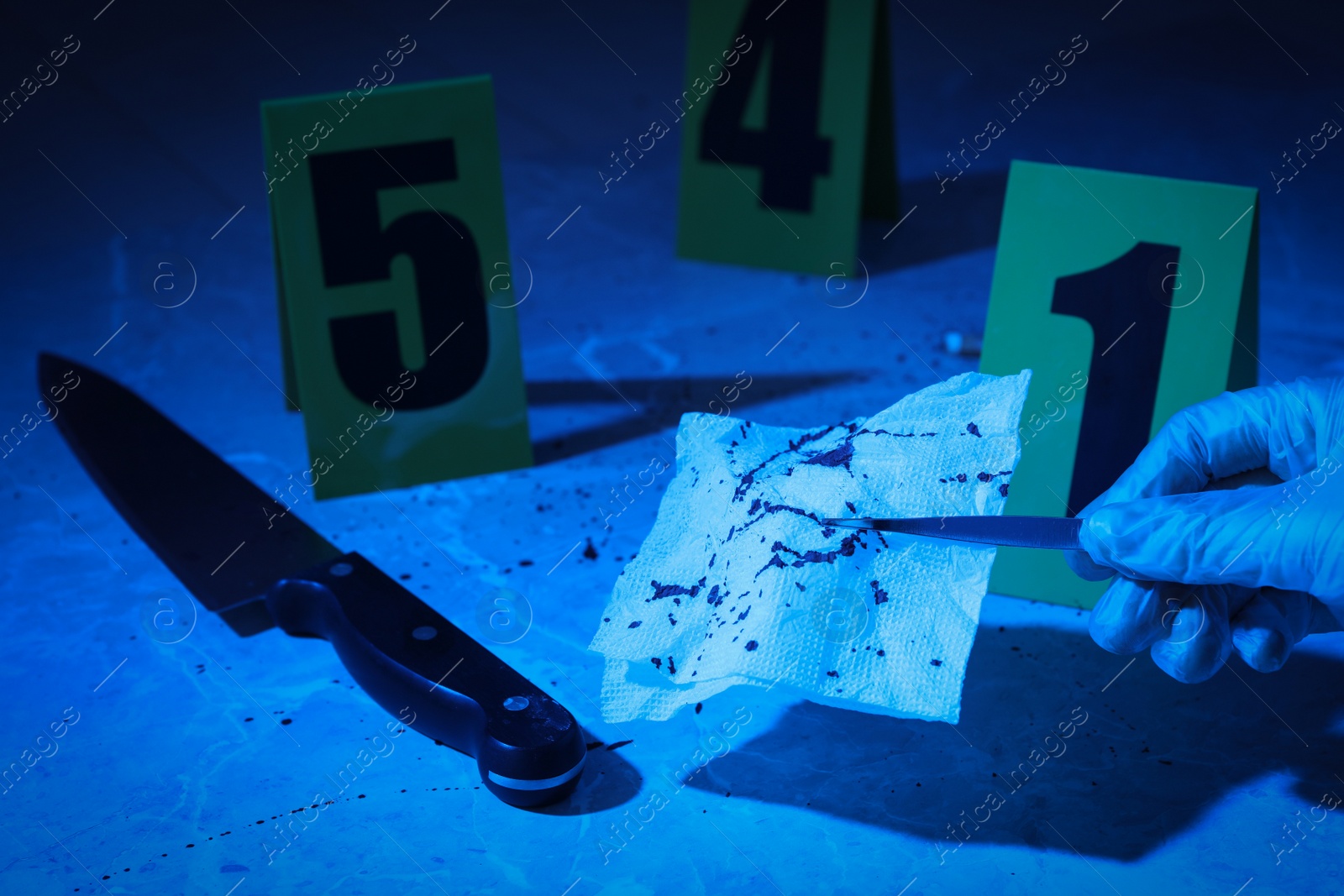 Photo of Closeup view of woman taking bloody napkin at marble background, toned in blue. Crime scene