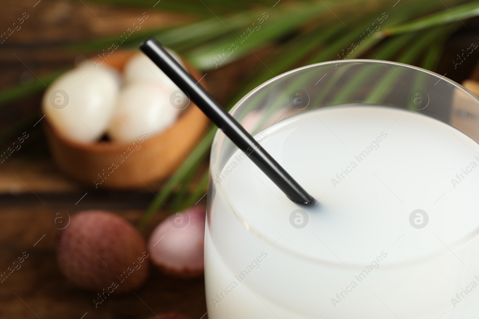 Photo of Freshly made lychee juice on wooden table, closeup