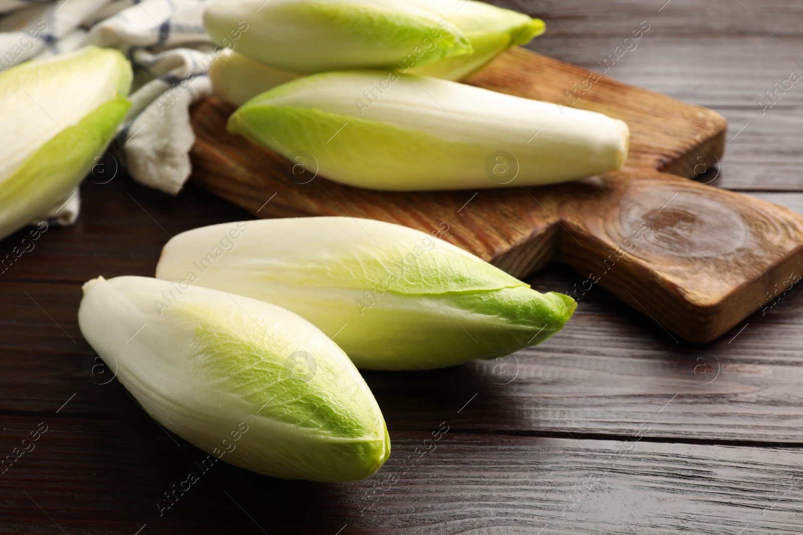 Photo of Raw ripe chicories on wooden table, closeup