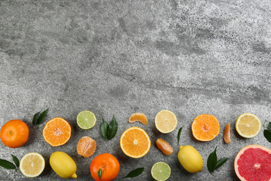 Flat lay composition with tangerines and different citrus fruits on grey background. Space for text