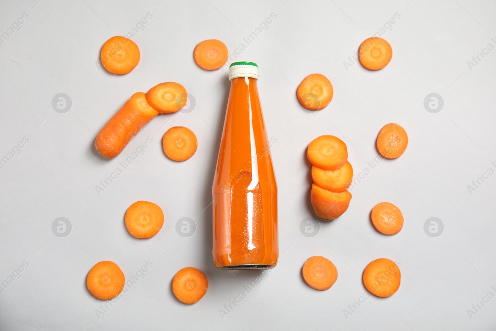 Photo of Flat lay composition with drink in bottle and cut carrot on color background