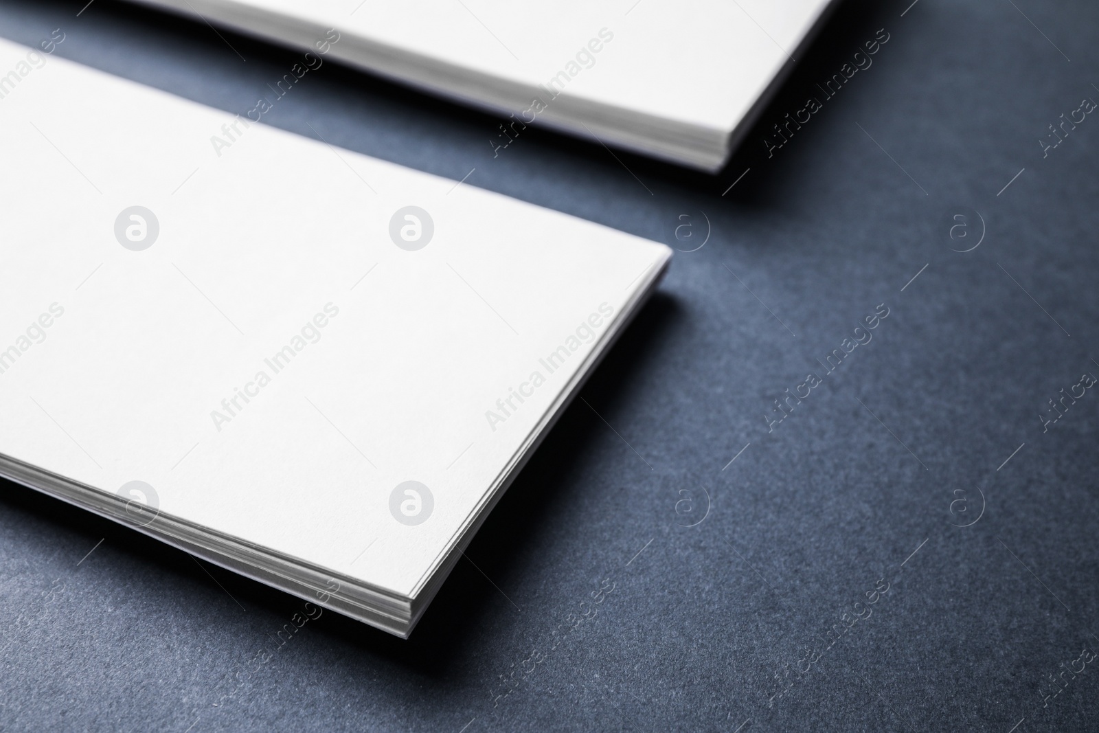 Photo of Blank business cards on dark grey background, closeup. Mock up for design