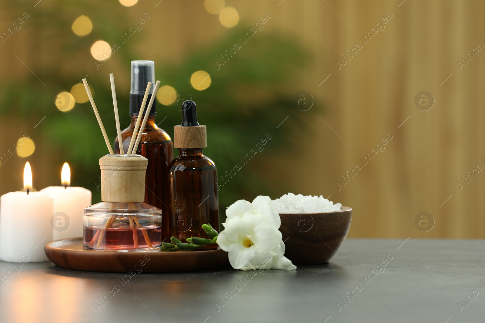 Photo of Composition with different spa products and burning candles on light grey table, space for text