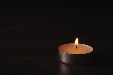 Photo of Burning candle on dark background, space for text. Symbol of sorrow