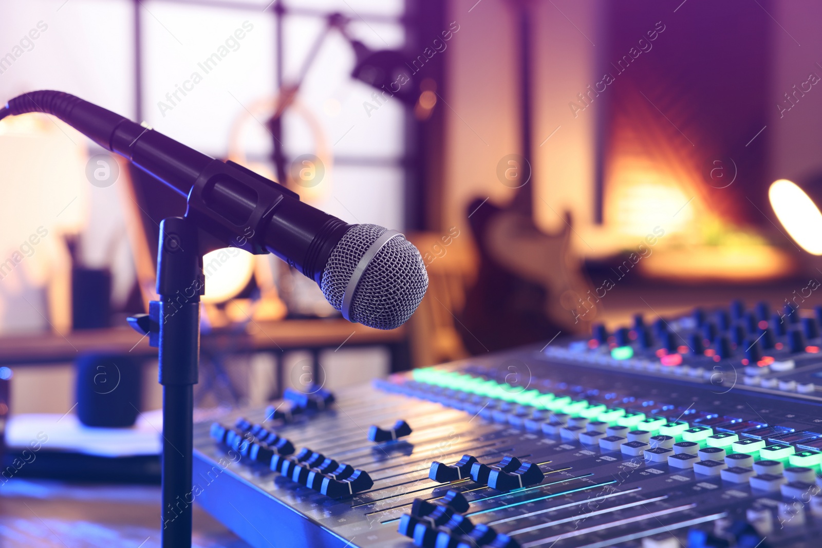 Photo of Microphone near professional mixing console in radio studio, closeup