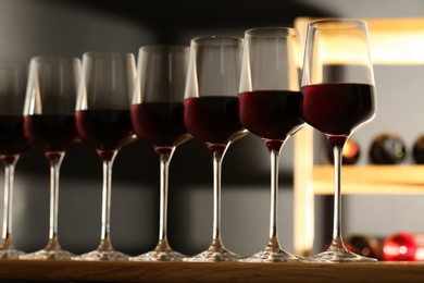 Photo of Glasses of red wine in cellar. Expensive drink