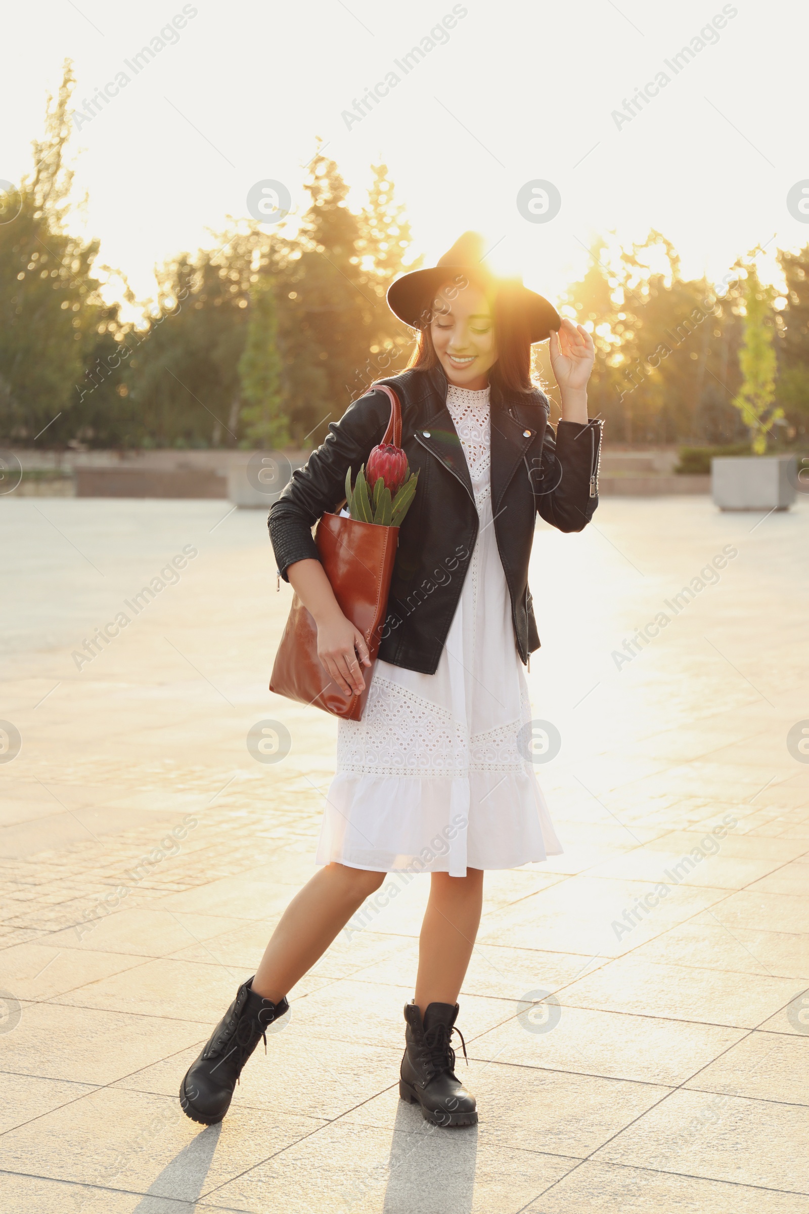 Photo of Young woman with leather shopper bag on city street