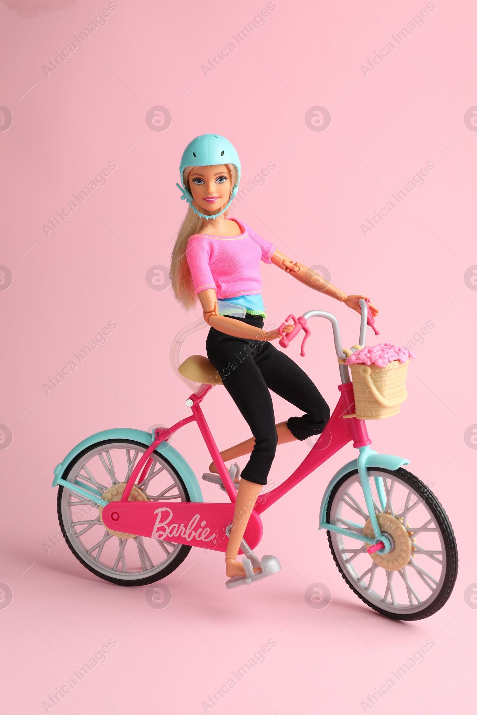 Photo of Mykolaiv, Ukraine - September 2, 2023: Beautiful Barbie doll with bicycle on pink background