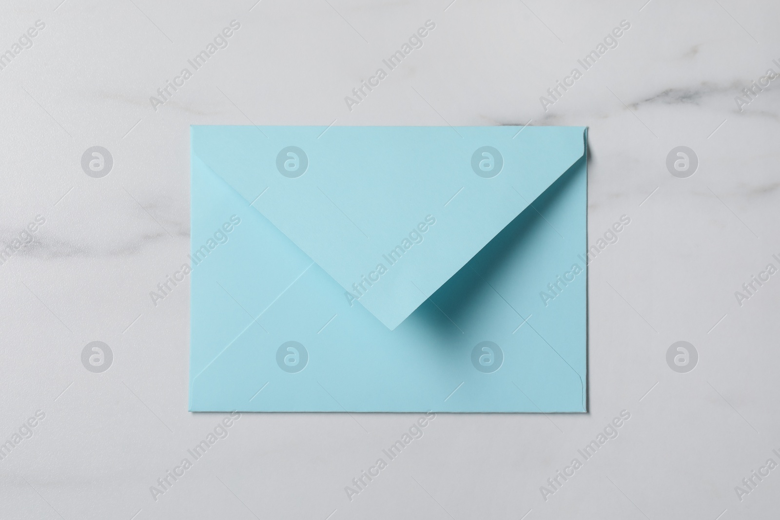 Photo of Letter envelope on white marble table, top view