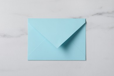 Letter envelope on white marble table, top view