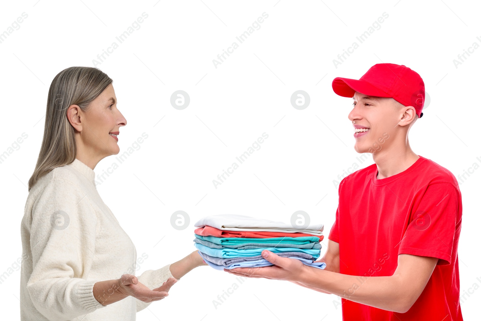 Image of Dry-cleaning delivery. Courier giving folded clothes to woman on white background