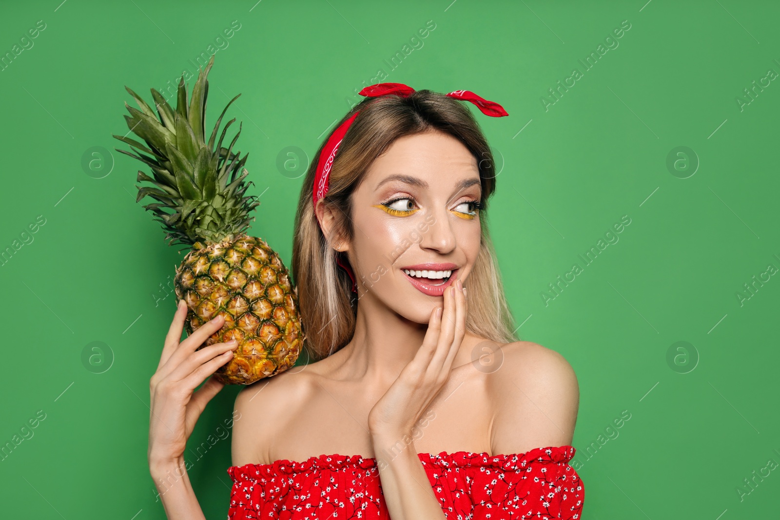 Photo of Young woman with fresh pineapple on green background. Exotic fruit