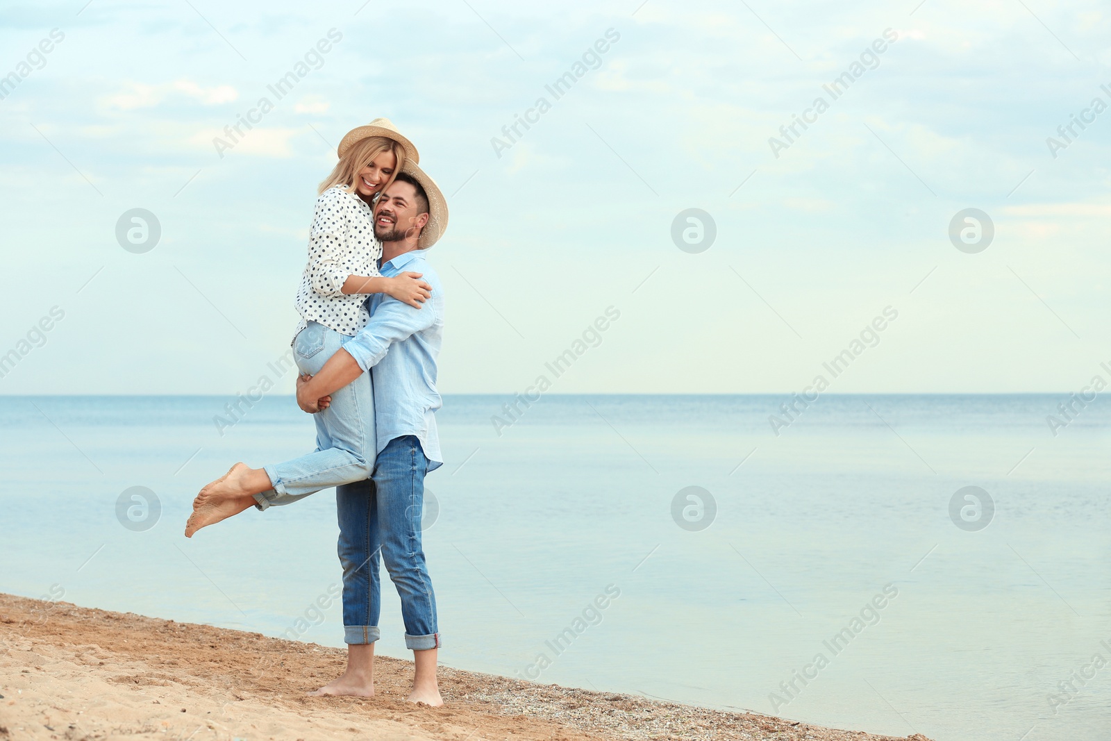 Photo of Happy romantic couple spending time together on beach, space for text