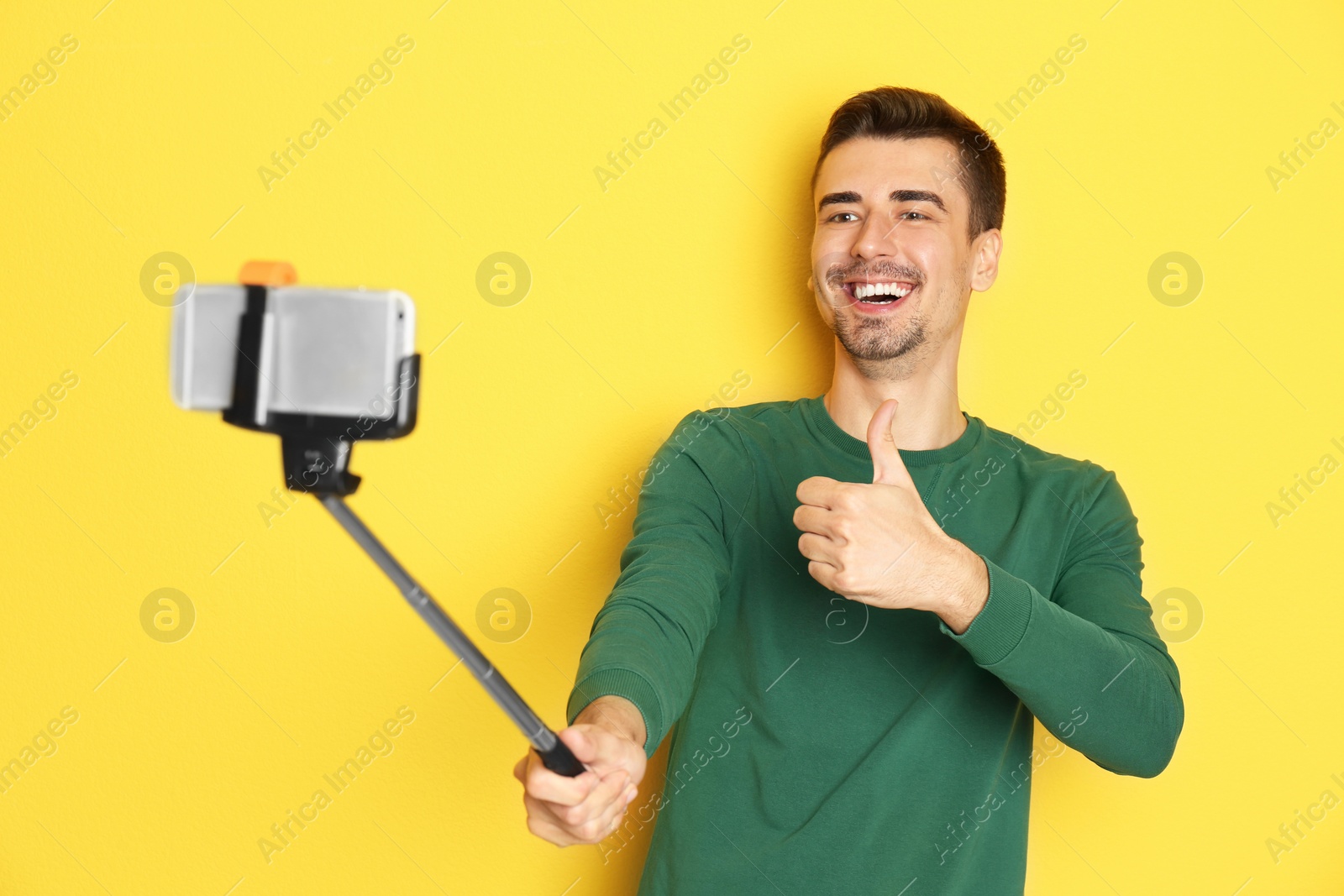 Photo of Young handsome man taking selfie against color background