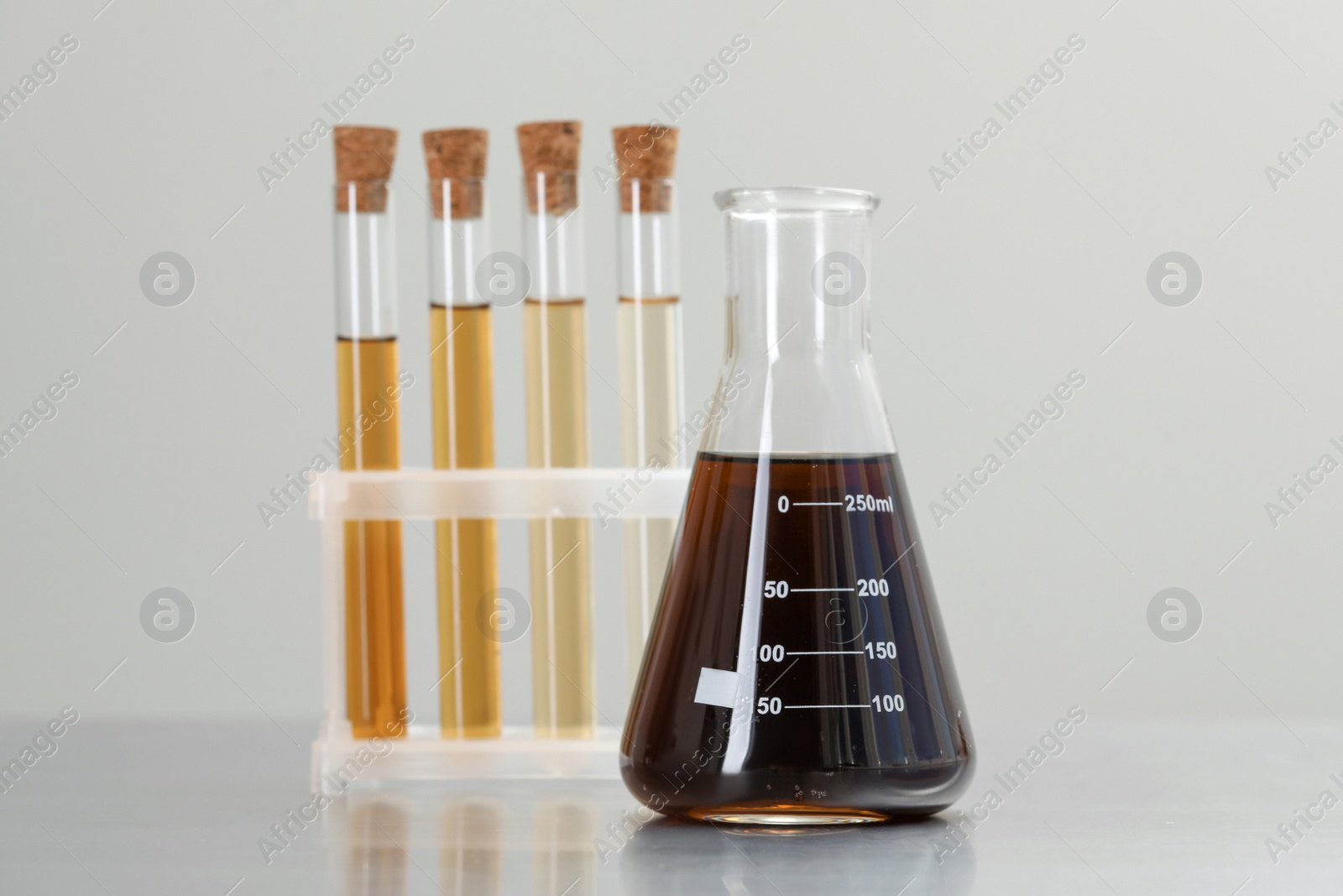 Photo of Laboratory glassware with brown liquids on light background