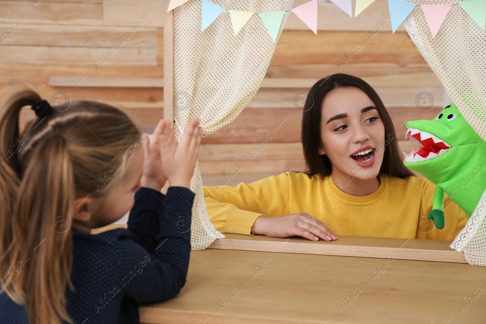 Photo of Mother performing puppet show for her daughter at home