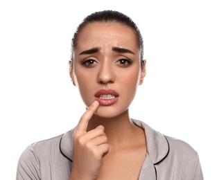 Emotional woman with herpes touching lips on white background