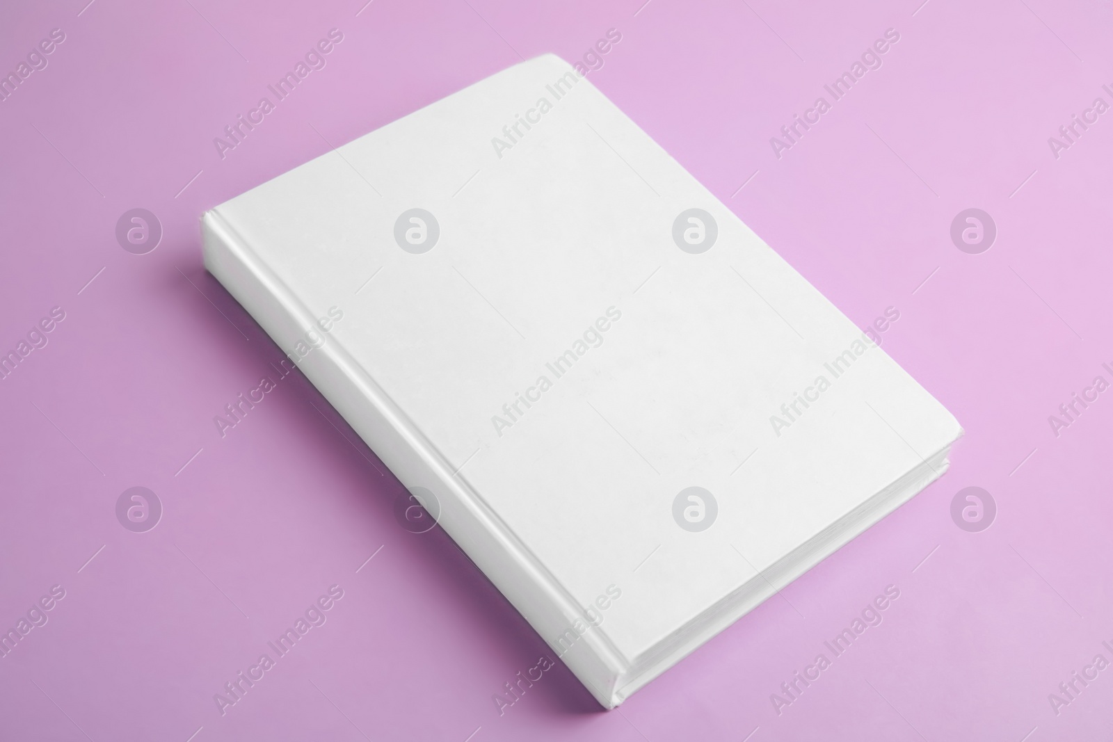 Photo of Book with blank cover on violet background
