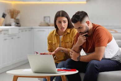 Young couple discussing family budget at home