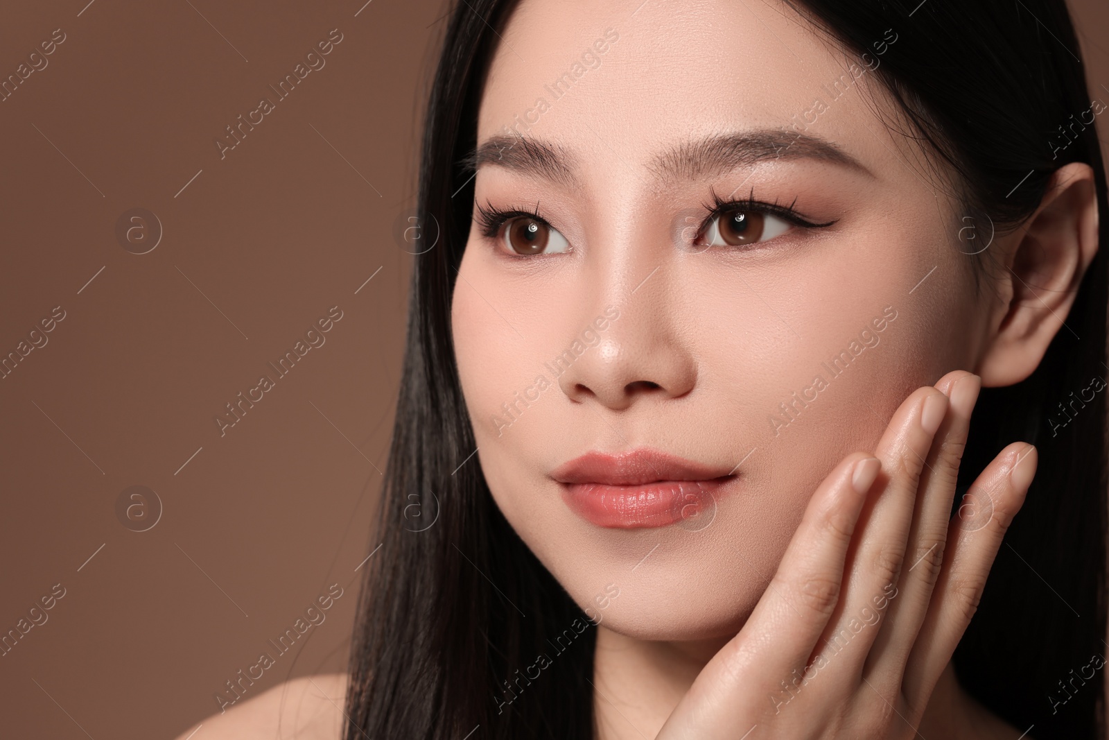 Photo of Portrait of beautiful woman on brown background