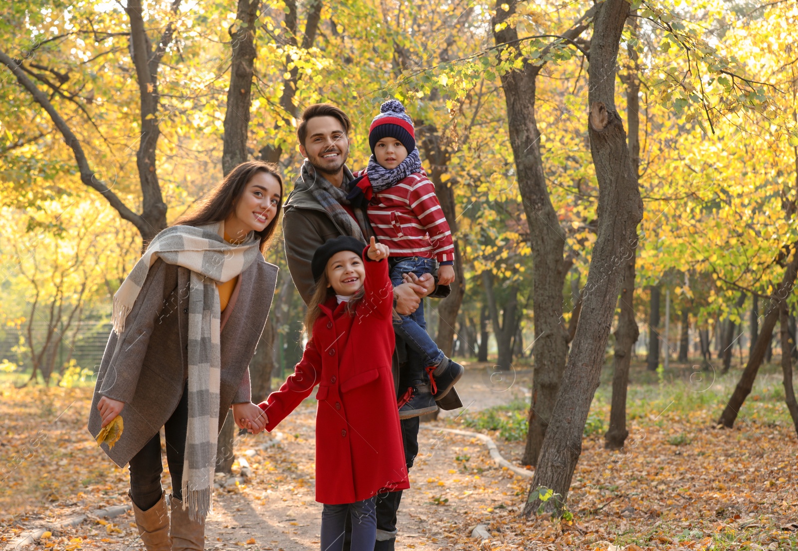 Photo of Happy family with children spending time together in park. Autumn walk