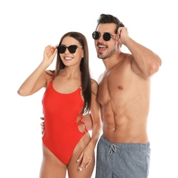 Photo of Young attractive couple in beachwear and sunglasses on white background