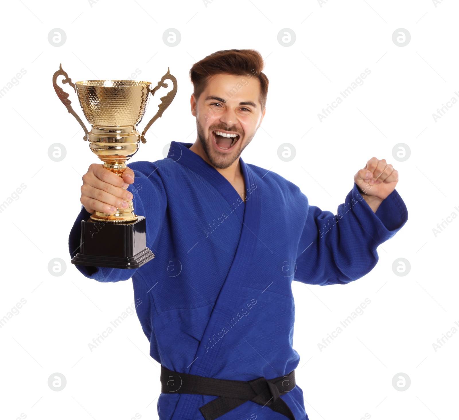 Photo of Portrait of happy young man in blue kimono with gold trophy cup on white background