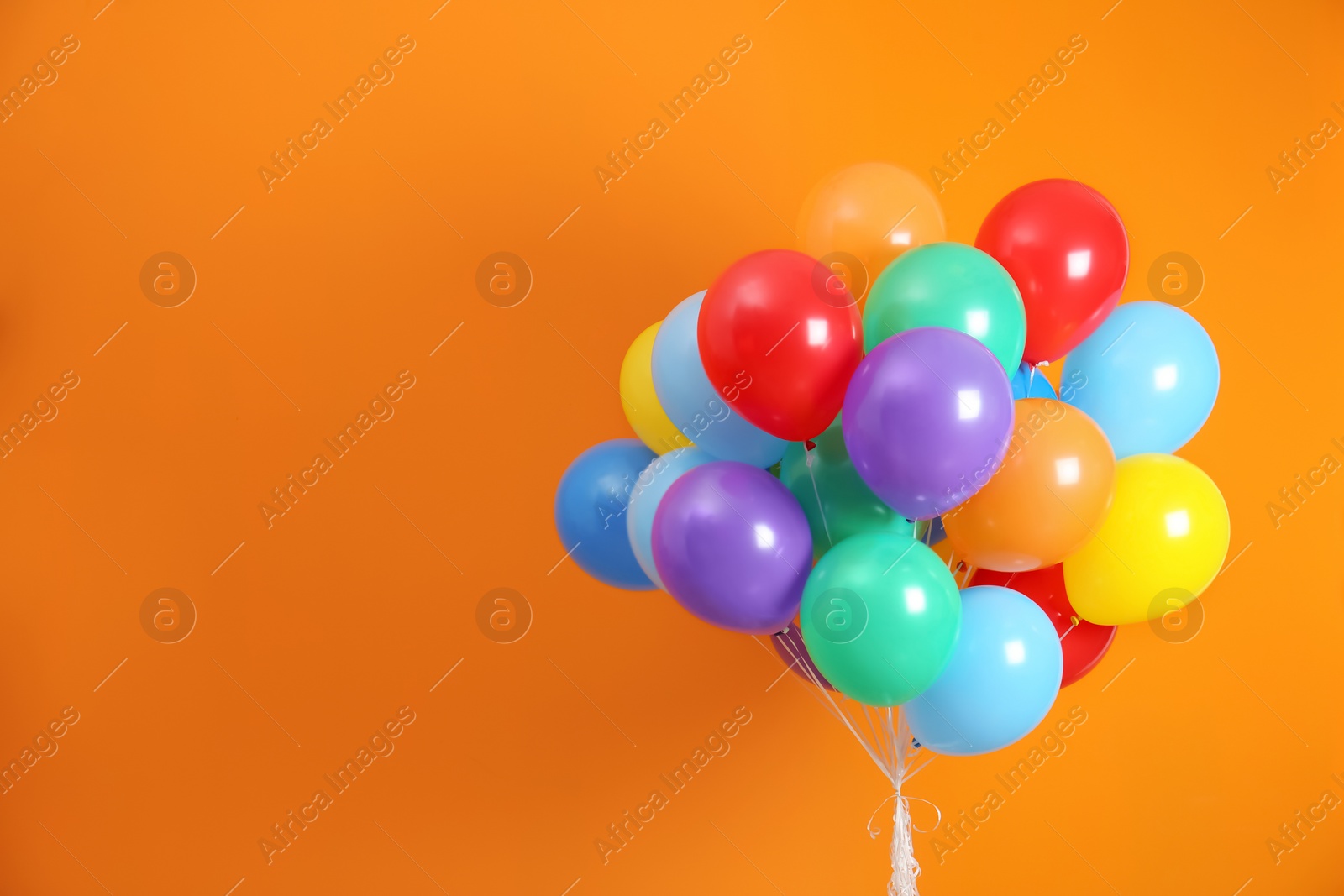 Photo of Bunch of bright balloons and space for text against color background